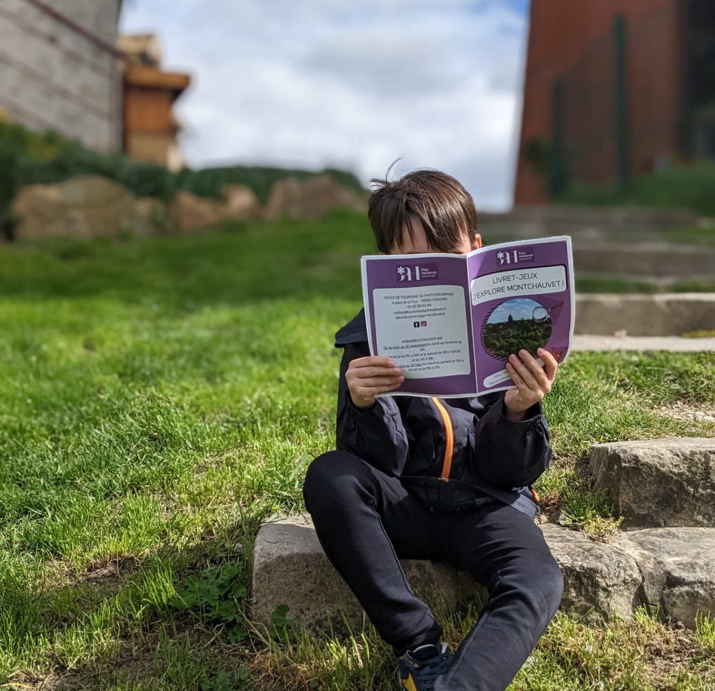 Child holding Montchauvet game booklet