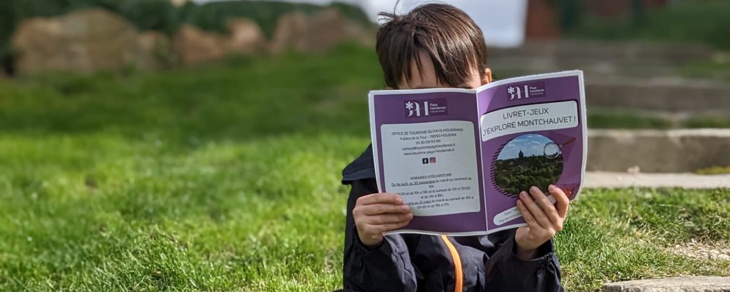 Child holding Montchauvet game booklet