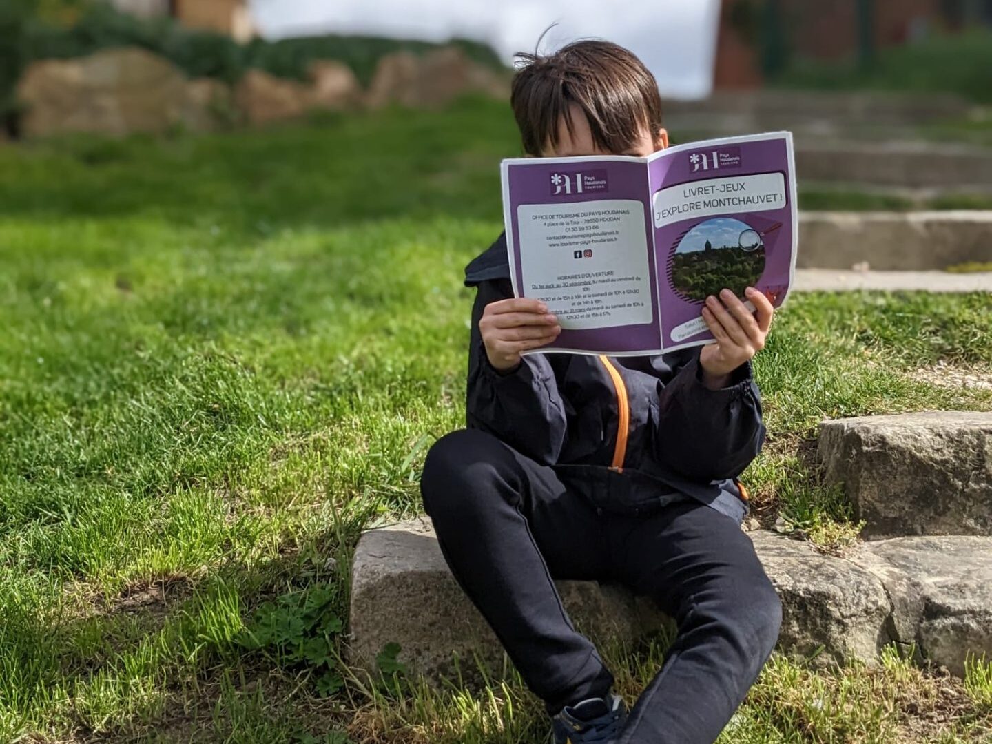 Child holding Montchauvet game booklet